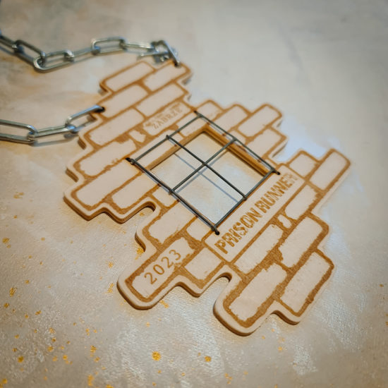 Sklejkowy medal Prison Runner z motywem muru i napisem "Prison Runner"